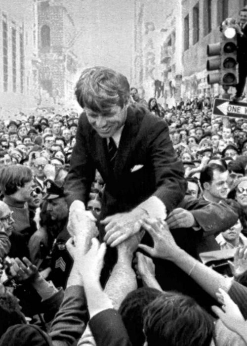 Senator Robert Kennedy is surrounded by hundreds of people as he leans down to shake hands during a campaign appearance at a street corner in central Philadelphia, April 2, 1968. (AP Photo)